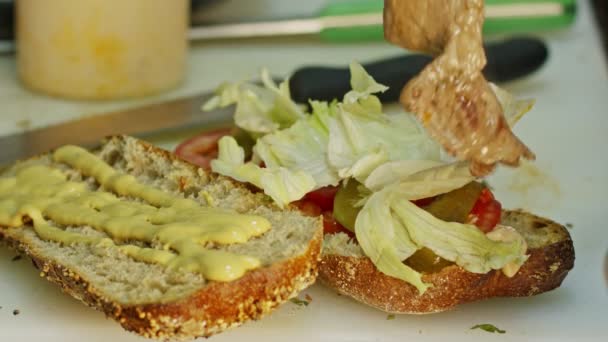 Hände in Nahaufnahme bei der Zubereitung von Roastbeef-Sandwich — Stockvideo