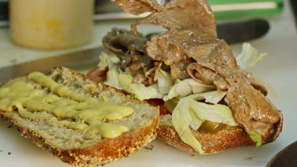 Primer plano de las manos preparando sándwich de carne asada — Vídeos de Stock