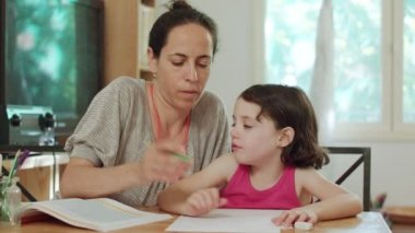 Küçük kızı evde ödev hazırlamak için yardımcı anne