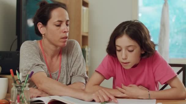 Mãe ajudando sua filha a preparar os trabalhos de casa em casa — Vídeo de Stock
