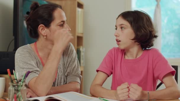 Мати допомагала її дочка підготувати домашнє завдання в домашніх умовах — стокове відео