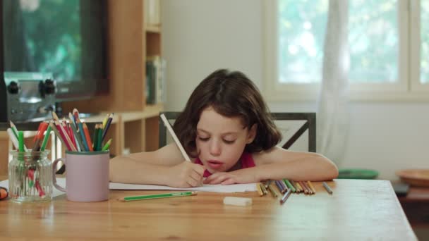 Niña sentada en la mesa dibujo con lápices de colores — Vídeos de Stock