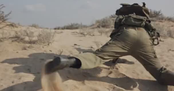 Soldado corriendo en una colina de arena durante el combate, bajo fuego — Vídeo de stock