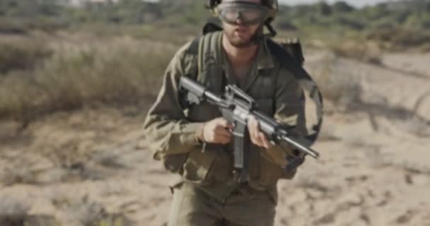 Soldato che corre su una collina di sabbia durante il combattimento, sotto il fuoco — Video Stock