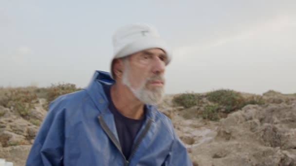 Oude visser op zoek naar de oceaan met zijn verrekijkers — Stockvideo