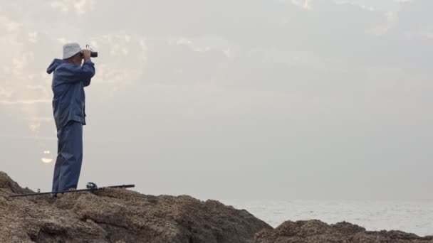 Viejo pescador mirando al océano usando sus prismáticos — Vídeos de Stock