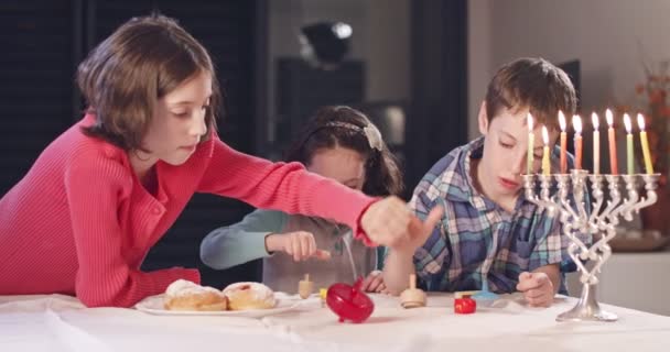 Gyerekek játszó dreidels során Hanukka otthon — Stock videók