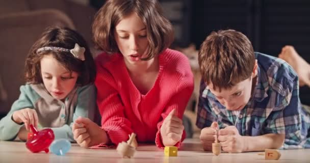 Τα παιδιά παίζουν με ντρέιντελ κατά τη διάρκεια Hanukka στο σπίτι — Αρχείο Βίντεο