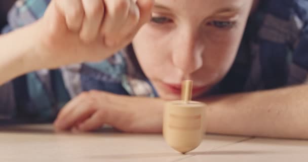 Close up tiro de um menino girando um dreidel Hanukka no chão — Vídeo de Stock