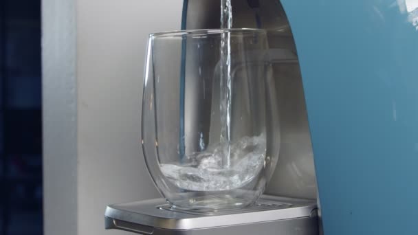 Mouvement lent d'une tasse d'eau remplissant une machine de filtration d'eau — Video