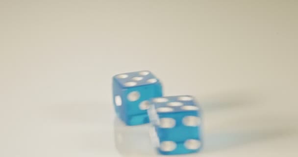 Slow motion macro shot of dice falling and rolling on reflective surface — Stock Video