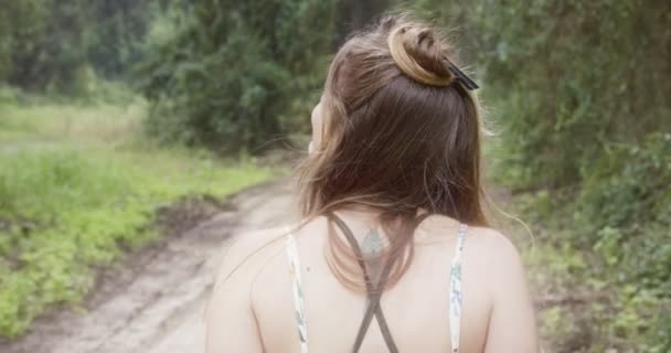 Yeşil bir ormanda yürüyüş beyaz bir elbise ile genç güzel kadın — Stok video