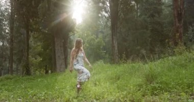 Yeşil bir ormanda yürüyüş beyaz bir elbise ile genç güzel kadın