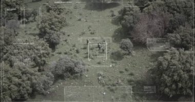 Hud grafikli bir ormanda yürüyen askerlerin gözetleme drone görünümü