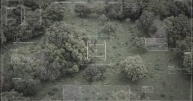 Hud grafikli bir ormanda yürüyen askerlerin gözetleme drone görünümü
