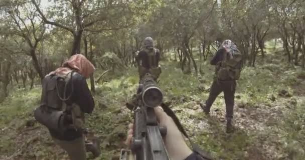 POV filmagem de terroristas islâmicos armados patrulhando uma área florestal — Vídeo de Stock