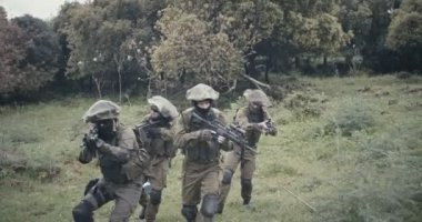 Bir orman sahnesinde savaş sırasında tam silahlı komando askerlerin in Mangası