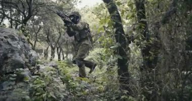 Bir orman sahnesinde savaş sırasında tam silahlı komando askerlerin in Mangası