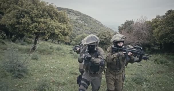 Squad of fully armed commando soldiers during combat in a forest scenery — Stock Video
