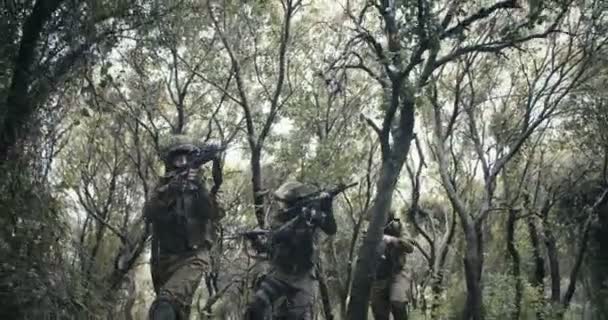 Trupp av fullt beväpnade Commando soldater under strid i en skog landskap — Stockvideo