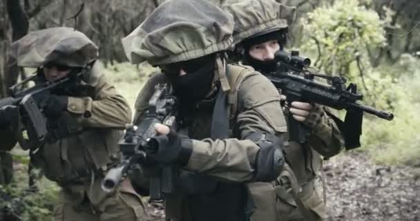 Skupina plně ozbrojených vojáků v boji v lesní scenérii — Stock video