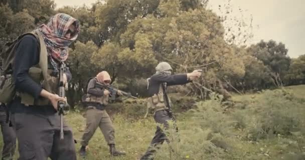 Skupina ozbrojených teroristů hlídaná v lesní oblasti během boje — Stock video
