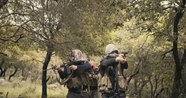 Escouade de terroristes armés patrouillant dans une zone forestière pendant le combat — Video