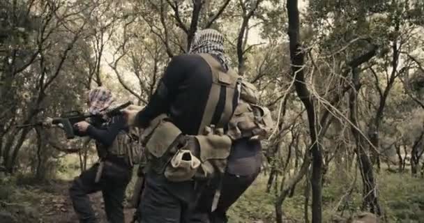 Escouade de terroristes armés patrouillant dans une zone forestière pendant le combat — Video