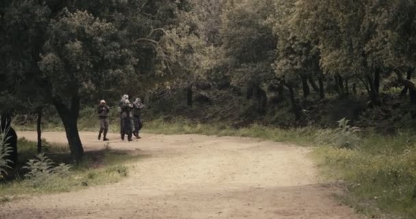 Team van gewapende terroristen patrouilleren een bosgebied tijdens gevechten — Stockvideo