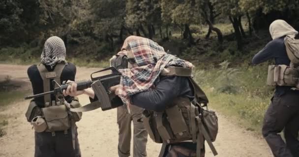 Отряд вооруженных террористов патрулирует лесные массивы во время боевых действий — стоковое видео