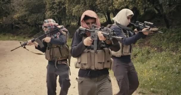 Skupina ozbrojených teroristů hlídaná v lesní oblasti během boje — Stock video