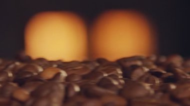 Arka planda fırın ateşi ile bir konveyör bant üzerinde kavrulmuş kahve çekirdekleri