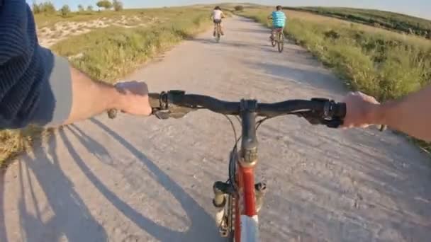 ПОВ двох дітей насолоджується велосипедною прогулянкою по сільській місцевості з батьком — стокове відео