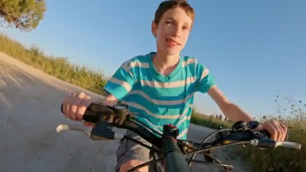 POV de um menino desfrutando de um passeio de bicicleta no campo rural — Vídeo de Stock