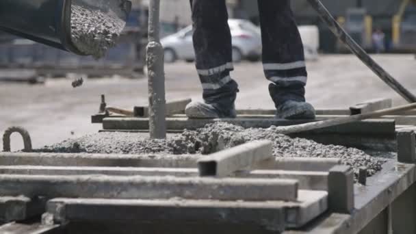 Dělníci nalévat beton do velkých ocelových molů na staveništi