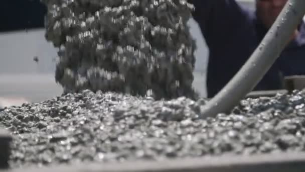 Travailleurs versant du béton dans de grands moules en acier sur un chantier de construction — Video