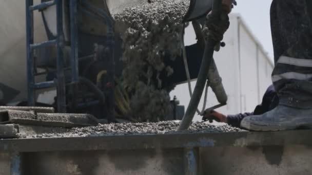 Arbeiter gießen auf einer Baustelle Beton in große Stahlformen