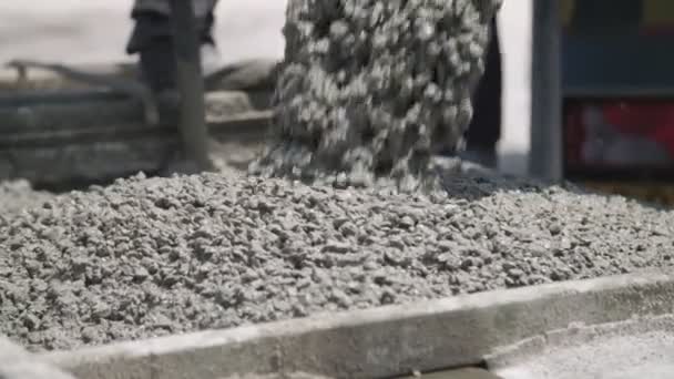 Рабочие заливают бетон в большие стальные формы на строительной площадке — стоковое видео