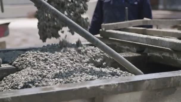 Travailleurs versant du béton dans de grands moules en acier sur un chantier de construction — Video