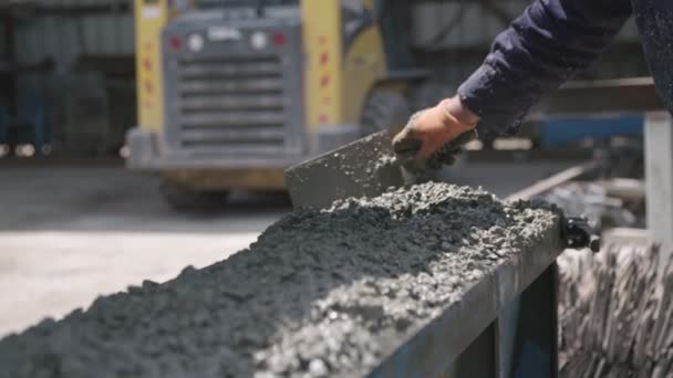Рабочие заливают бетон в большие стальные формы на строительной площадке — стоковое видео