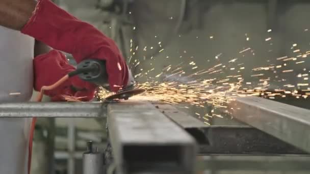 Powolny ruch pracownika przy użyciu szlifierki metalu z iskrami pływające w metalowym sklepie — Wideo stockowe