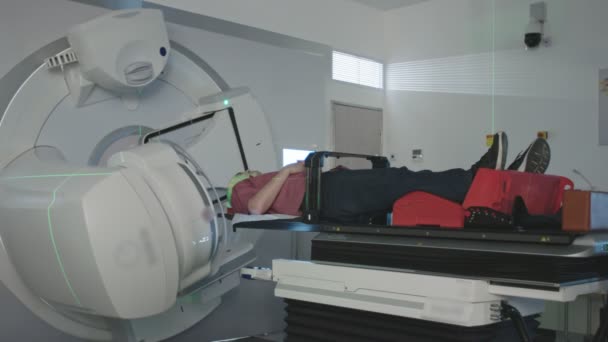 Пациент получает лучевую терапию лечение внутри современной комнаты лучевой терапии — стоковое видео
