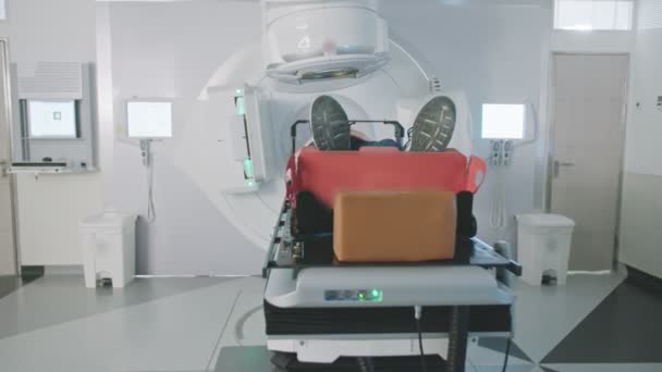Pacient získání léčby radiační terapií uvnitř moderního radioterapeutické místnosti — Stock video