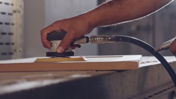 Mouvement lent d'un ouvrier polissant une porte d'armoire dans une usine de meubles — Video