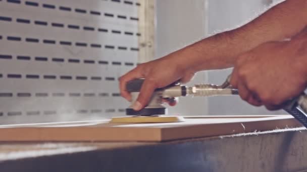 Mouvement lent d'un ouvrier polissant une porte d'armoire dans une usine de meubles — Video