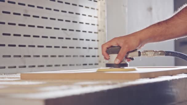 Mouvement lent d'un ouvrier polissant une porte d'armoire dans une usine de meubles — Video