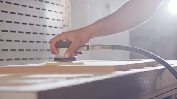 Mouvement lent d'un ouvrier polissant une porte d'armoire dans une usine de meubles — Video