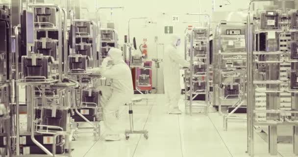 Trabajadores en sala limpia en una planta de fabricación de semiconductores — Vídeos de Stock