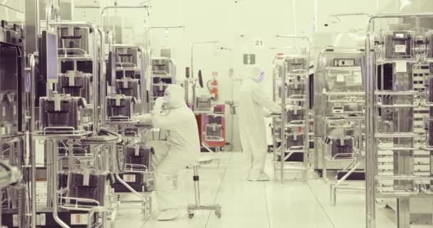 Travailleurs en salle blanche dans une usine de fabrication de semi-conducteurs — Video