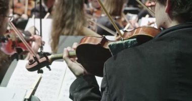 Konser öncesi klasik müzik provası sırasında keman çalan müzisyen